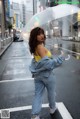 A woman standing in the middle of a street holding an umbrella.