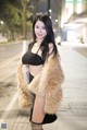 A woman in a fur coat is posing for a picture.