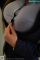 A woman in a business suit is putting on her shirt.