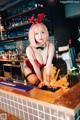 A woman in a bunny costume sitting at a bar.