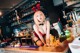 A woman in a red lingerie sitting at a bar.