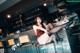 A woman sitting on a bar stool in a restaurant.