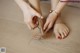 A woman is cutting her feet with a pair of scissors.