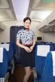 A woman standing in the middle of an airplane.