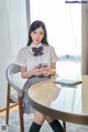 A woman sitting at a table with a cell phone in her hand.