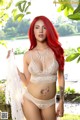 A woman with red hair wearing a white lingerie.