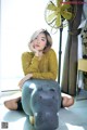 A woman sitting on the floor next to a stuffed hippo.