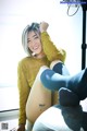 A woman sitting on top of a couch next to a window.