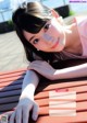 A woman laying on top of a wooden bench.