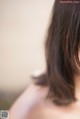 A woman with long brown hair is looking away from the camera.