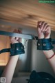 A person holding a pair of handcuffs in their hands.