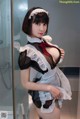 A woman in a maid outfit posing for a picture.