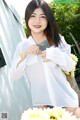 A woman in a white shirt is posing for a picture.