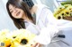 A woman holding a bunch of sunflowers next to a bike.