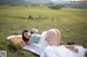 A woman laying on a blanket in a field.