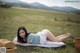 A woman laying on a blanket in a field.