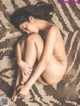 A naked woman laying on a zebra print rug.