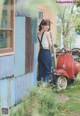 A woman standing next to a red scooter in front of a building.