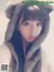 A young woman wearing a bear hat and a fur coat.