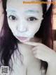 A woman with a sheet mask on her face.