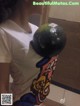 A woman holding a bowling ball on her shoulder.