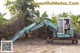 A woman sitting in an excavator in the middle of a field.