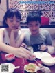 A boy and a girl sitting at a table eating food.