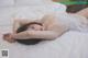 A woman laying on a bed in a white lingerie.