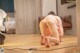 A woman kneeling on the floor in front of a television.