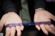 A close up of a person holding a blue ribbon in their hands.