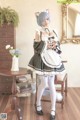 A woman dressed in a maid outfit posing for a picture.