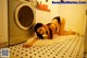 A woman laying on the floor in front of a washing machine.