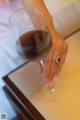 A woman's hand holding a glass of red wine.