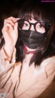 A woman wearing a black mask and glasses.