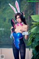 A woman dressed as a bunny holding a gun.