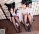 A couple of women sitting on top of a wooden floor.