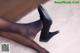 A close up of a woman's legs wearing black high heels.