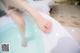 A woman's feet in a bathtub of water.