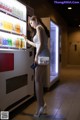 A woman standing in front of a vending machine.