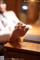 A woman sitting at a table with her feet up on a laptop.