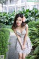 A woman in a floral dress posing for a picture.