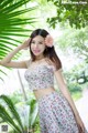 A woman in a floral dress posing for a picture.