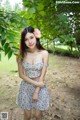 A woman in a floral dress posing for a picture.