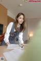 A woman in a school uniform is looking at a book.