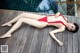 A woman in a red bikini laying on a wooden deck.