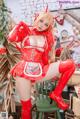 A woman in a red latex outfit sitting on a chair.