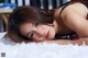 A woman laying on top of a white rug.