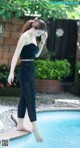 A woman standing on the edge of a swimming pool.