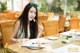 A woman sitting at a table with a plate of food.