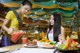 A woman serving food to another woman at a restaurant.